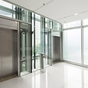 Brandschutzfenster - Feststehende Verglasung in einem Treppenhaus - vollverglaste Außenflächen sowie Verglasung zwischen den beiden dargestellten Fahrstühlen - deckenhoch, vollverglast, feuerschützend
